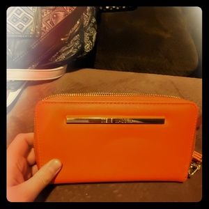 Reddish orange steve madden wallet.